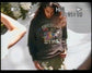 A person wearing a dark gray hoodie with 'OREGON STATE' and a multicolor graphic printed on the front, standing outdoors against a bright white background. The image has a retro VHS monitor overlay with battery, time, and play icons.