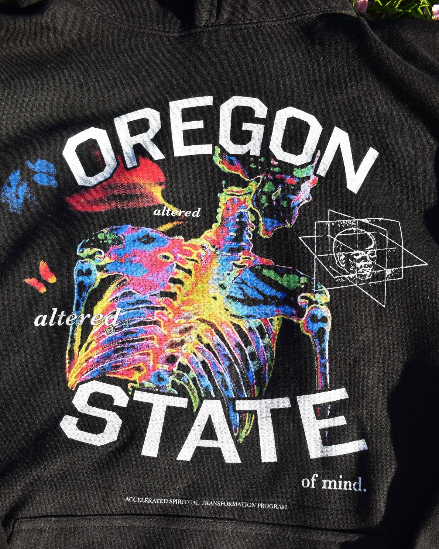 Close-up of black Oregon State of Mind hoodie with colorful psychedelic skeleton graphic